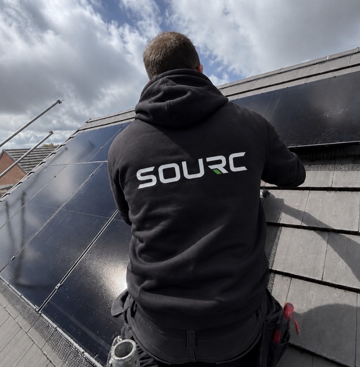 A SOURC engineer installing solar panels on a roof
